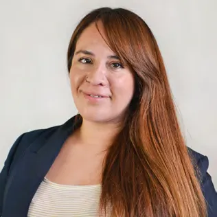 Portrait of Sofía Aliaga, with long hair and a dark blue jacket.